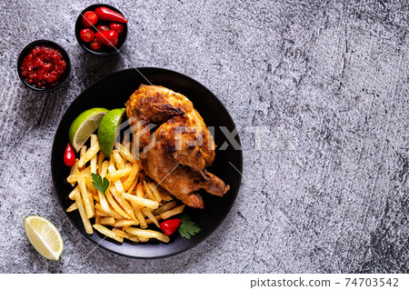Half roasted chicken Piri Piri with french fries 74703542