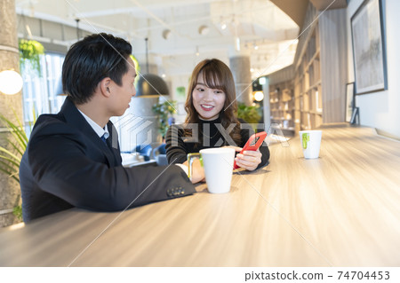 A couple talking in a cafe 74704453