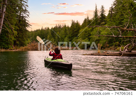 Adventurous Girl kayaking in the Pacific Ocean. 74706161