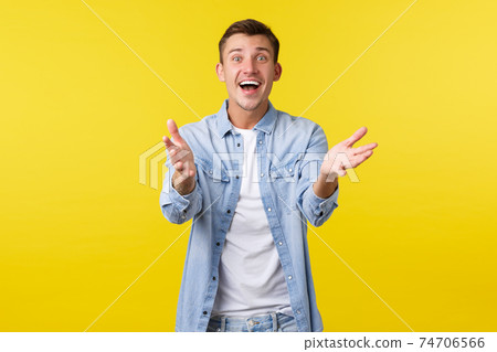 Happy excited handsome man reaching hands forward and smiling amazed, want hold or take something precious, glad to hear fantastic awesome news, receive gift, sanding yellow background Happy excited handsome man reaching hands forward and smiling amazed, want hold or take something precious, glad to hear fantastic awesome news, receive gift, sanding yellow background 74706566
