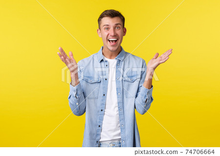 Happy excited handsome guy clap hands, react to fantastic news, congratulating friend with achievement, applause and smiling upbeat, standing enthusiastic over yellow background 74706664