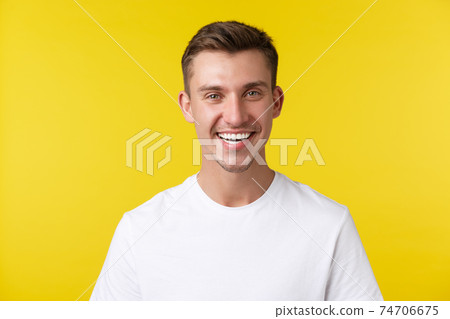 Lifestyle, summer and people emotions concept. Enthusiastic handsome male model with happy smile and white teeth, standing in casual t-shirt over yellow background satisfied Lifestyle, summer and people emotions concept. Enthusiastic handsome male model with happy smile and white teeth, standing in casual t-shirt over yellow background satisfied 74706675