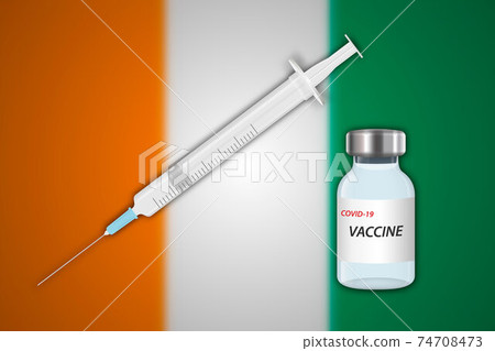 Syringe and vaccine vial on blur background with Ivory Coast fla 74708473