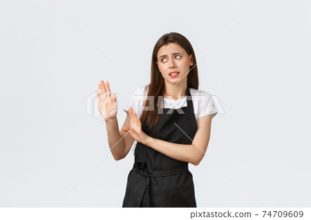 Grocery store employees, small business and coffee shops concept. Disgusted and reluctant barista avoiding strange guest. Displeased saleswoman raising hands defensive in rejection Grocery store employees, small business and coffee shops concept. Disgusted and reluctant barista avoiding strange guest. Displeased saleswoman raising hands defensive in rejection 74709609