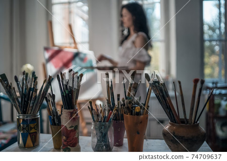 woman artist paint with brushes and oil dye woman artist paint with brushes and oil dye 74709637