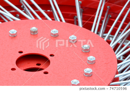 New red tedder for trailer in agricultural machinery for gathering hay. Close up 74710596