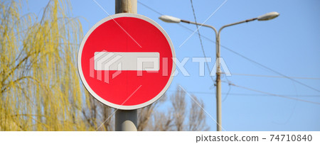 Road sign in the form of a white rectangle in a red circle. No entry Road sign in the form of a white rectangle in a red circle. No entry 74710840