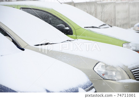 Fragments of parked cars covered with snow 74711001
