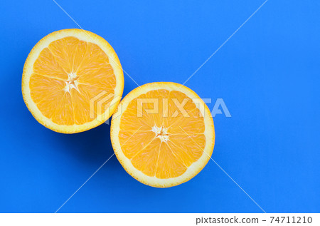 Top view of a several orange fruit slices on bright background in blue color. A saturated citrus texture image Top view of a several orange fruit slices on bright background in blue color. A saturated citrus texture image 74711210