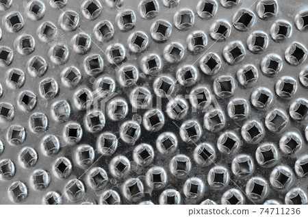 A fragment of a metal chrome grater close-up. Texture of blades for grinding food 74711236