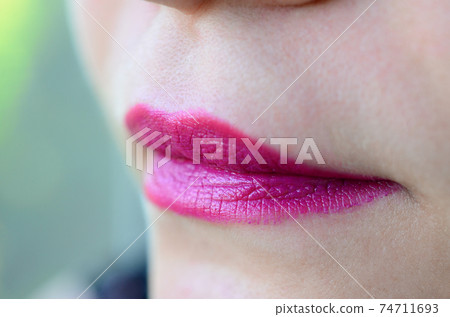 Close up shot of woman lips with glossy fuchsia lipstick Close up shot of woman lips with glossy fuchsia lipstick 74711693