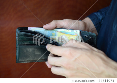 Close up male hands opened the wallet or purse with ukrainian money currency hryvnia 74711973