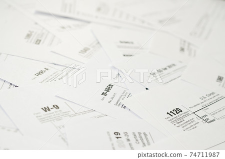 Many tax form blanks lies on table close up. Tax payers paperwork routine and bureaucracy concept 74711987