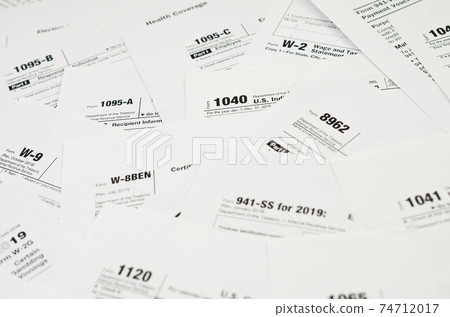Many tax form blanks lies on table close up. Tax payers paperwork routine and bureaucracy concept 74712017
