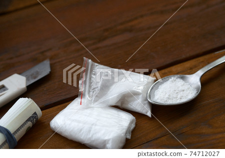 Lighter and spoon full of white powder on wooden background. Heroin drug addiction concept Lighter and spoon full of white powder on wooden background. Heroin drug addiction concept 74712027