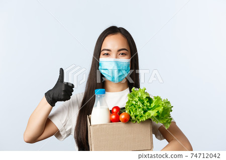 Covid-19, grocery store, employment, small business and preventing virus concept. Confident and cheerful shop employee, cashier in medical mask and gloves provide safe shopping during coronavirus 74712042