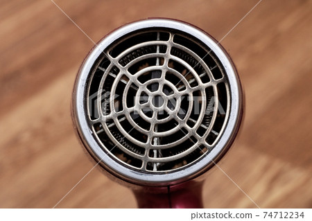 Fan blow dryer closeup on wooden background Fan blow dryer closeup on wooden background 74712234