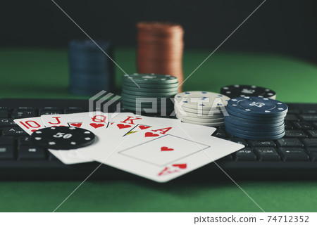 Online gaming platform, casino and gambling business. Cards, dice and multi-colored game pieces on laptop keyboard on green background Online gaming platform, casino and gambling business. Cards, dice and multi-colored game pieces on laptop keyboard on green background 74712352