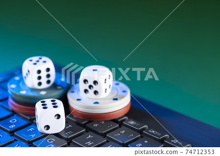 Online gaming platform, casino and gambling business. Dice on laptop keyboard on green background Online gaming platform, casino and gambling business. Dice on laptop keyboard on green background 74712353