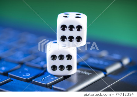 Online gaming platform, casino and gambling business. Dice on laptop keyboard on green background Online gaming platform, casino and gambling business. Dice on laptop keyboard on green background 74712354