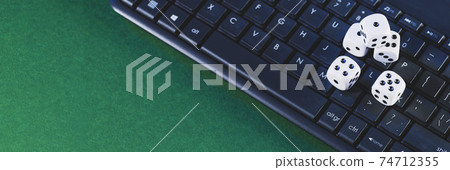 Online gaming platform, casino and gambling business. Dice on laptop keyboard on green background Online gaming platform, casino and gambling business. Dice on laptop keyboard on green background 74712355
