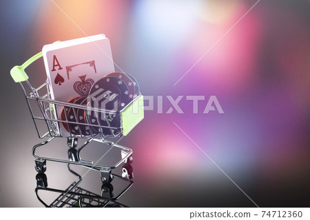 Casino chips and cards for playing the casino in a cart on a background with bokeh. Online gambling. Dependence Casino chips and cards for playing the casino in a cart on a background with bokeh. Online gambling. Dependence 74712360