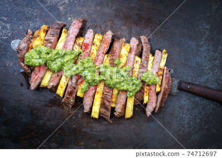barbecue dry aged wagyu flank steak with pineapples and chimichurri sauce  74712697