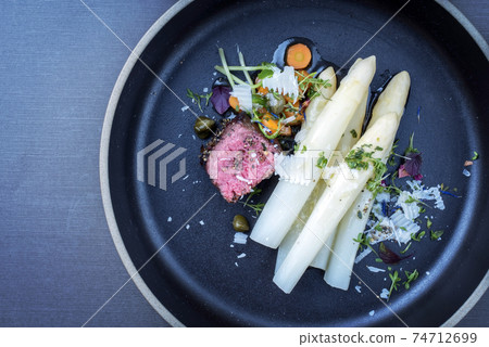 dry aged tagliata di manzo with white asparagus and parmesan 74712699