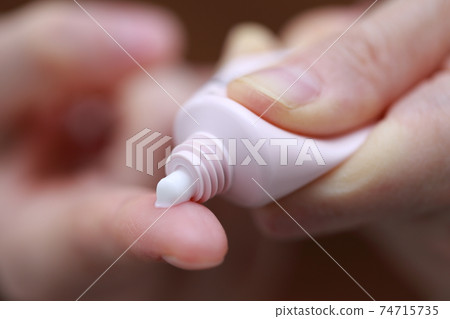 Female finger pushing out the ointment 74715735