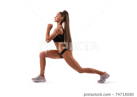 Smiling fit woman in underwear doing sport exercise in studio 74718080