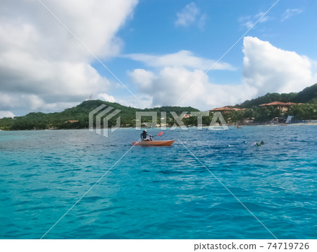 Dark clouds over Roatan island beache 74719726
