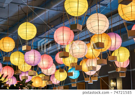 Colorful paper lanterns hang on ceiling in the mall 74721585
