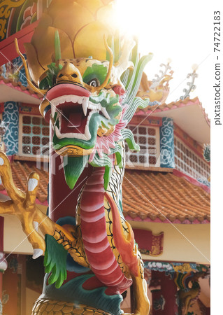 Close-up statue of a dragon wrapped around a pole in Chinese temple, vertical view. 74722183