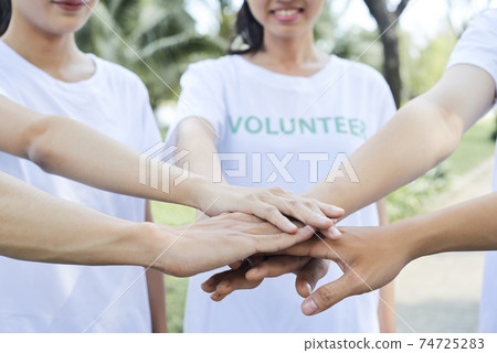 Volunteers standing hands 74725283