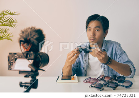 Asian Vlogger or Blogger Review Black Fashion Glasses and Recording Video in Vintage Tone Asian Vlogger or Blogger Review Black Fashion Glasses and Recording Video in Vintage Tone 74725321