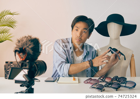 Asian Vlogger or Blogger Point Fashion Glasses and Recording Video in Vintage Tone Asian Vlogger or Blogger Point Fashion Glasses and Recording Video in Vintage Tone 74725324