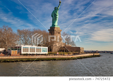 The Statue of Liberty in New York City USA daylight view from the back in Liberty Island with clouds in the sky in background The Statue of Liberty in New York City USA daylight view from the back in Liberty Island with clouds in the sky in background 74725472