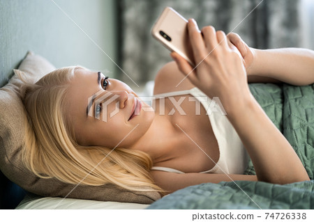 Girl looking at a cute photo on the phone 74726338
