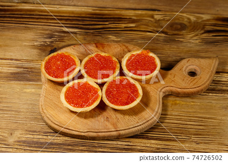 Tartlets with red caviar on a wooden table 74726502