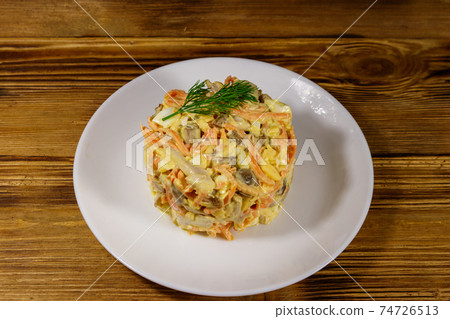 Tasty salad with chicken breast, roasted mushrooms, carrots, grated cheese, eggs and mayonnaise on wooden table 74726513