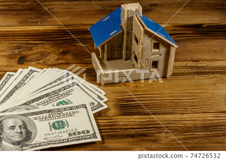 House model and U.S. one hundred dollar bills on wooden background. Property investment, home loan, house mortgage, real estate concept 74726532
