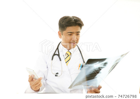 A smiling doctor with an X - ray picture 74726798