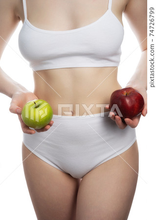 A female holding a red and green apples in different arms isolated on white background. 74726799