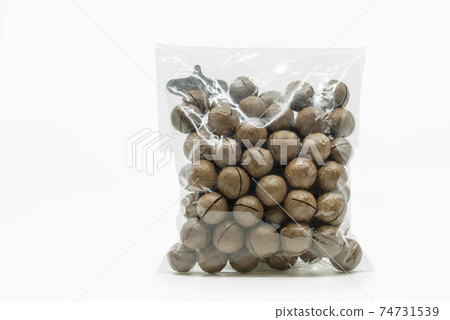 Macadamia nuts in shell and cracker tool in cleared plastic packaging on white background. Isolated plastic bag of Macadamia nuts with clipping path. Front view, blank space for label branding design. Macadamia nuts in shell and cracker tool in cleared plastic packaging on white background. Isolated plastic bag of Macadamia nuts with clipping path. Front view, blank space for label branding design. 74731539