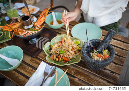 Woman having a meal with Pad see ew noodles in a Thai restaurant 74731665
