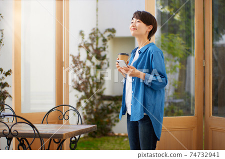 一個女人在一家咖啡館看智能手機 74732941