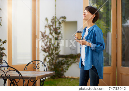 一個女人在一家咖啡館看智能手機 74732942