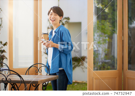 A woman watching a smartphone at a cafe A woman watching a smartphone at a cafe 74732947