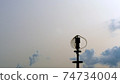 Vertical axis wind turbine utilize renewable wind energy while spinning against blue sky. 74734004