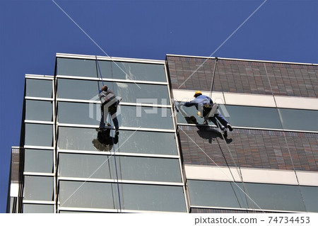 Cleaning the window glass of a building Cleaning the window glass of a building 74734453